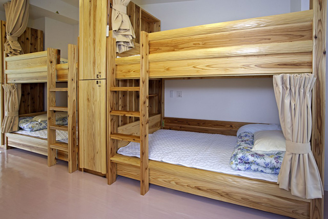 杉のフレームに北山丸太をデザイン的に使用した2段ベッドとロッカー※宇多野ユースホステル提供
